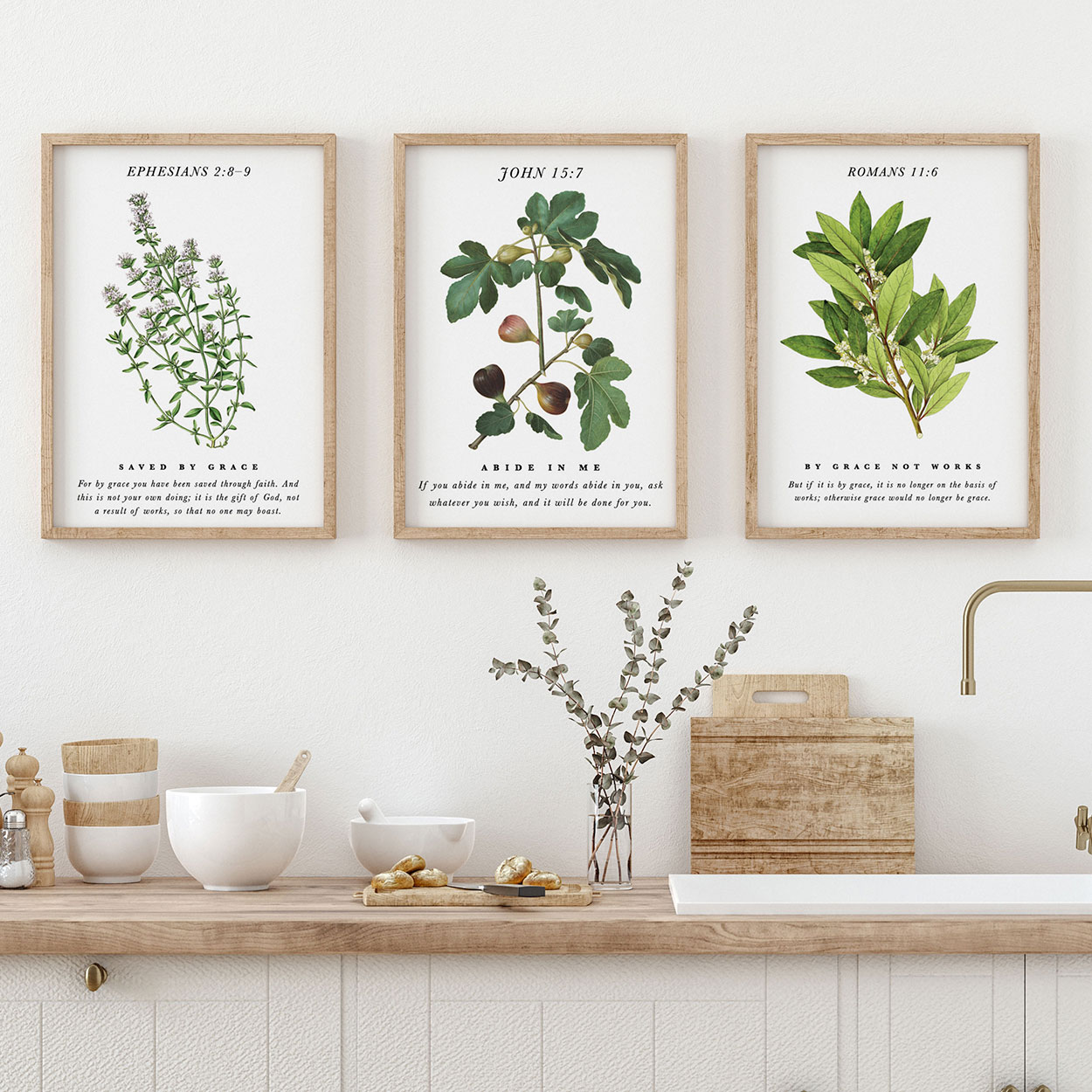 Three botanical Scripture art prints above a kitchen counter