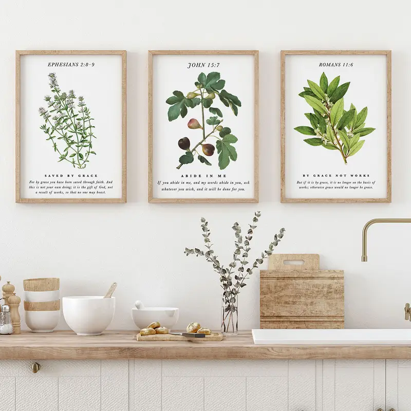 Three botanical Scripture art prints above a kitchen counter